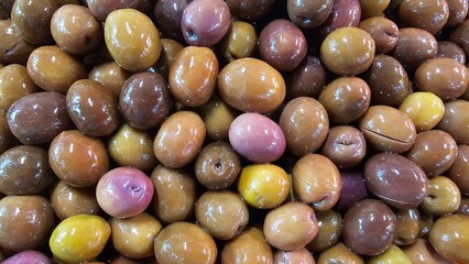 Close-Up of Juicy Olives in Various Colors - Green, Black, Purple, Red, Pink, and Brown Olives market