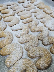 Buttery Crescent-Shaped Cookies with Powdered Sugar on Baking Sheet or in Box