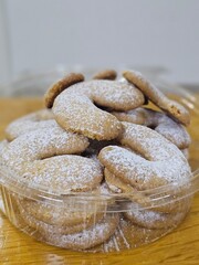 Buttery Crescent-Shaped Cookies with Powdered Sugar on Baking Sheet or in Box
