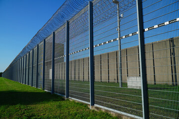 High security fence with spiky Nato wire rolls on top at a German prison in Hanover, Lower Saxony, Germany. Barbed wire to stop prisoners from escaping.