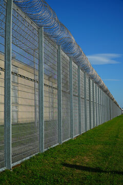 High security fence with spiky Nato wire rolls on top at a German prison in Hanover, Lower Saxony, Germany. Barbed wire to stop prisoners from escaping.