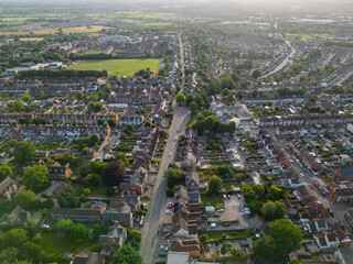Road and small roundabout in Swindon town UK at sunset in the summer. Aerial view with sun glare....