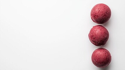 Tiga bola es krim berwarna merah muda di atas latar belakang putih.
