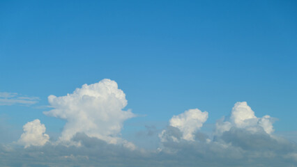 White fluffy clouds in a clear blue sky. Landscape photography. Nature and weather concept for design and print