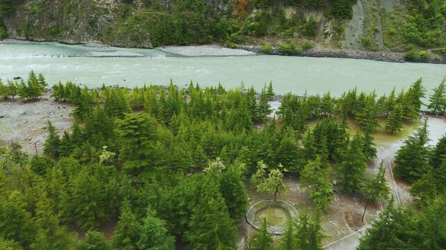4K Aerial view of river flowing between pine trees forest in Mini Manali at Udaipur, Himachal Pradesh, India. Nature Landscape. Travel and Holidays background.