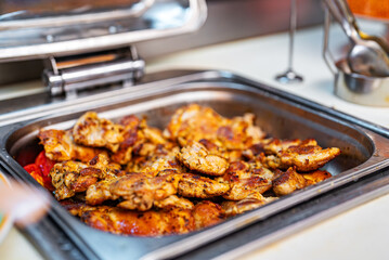 Lots of fried chicken thighs in a metal tray.