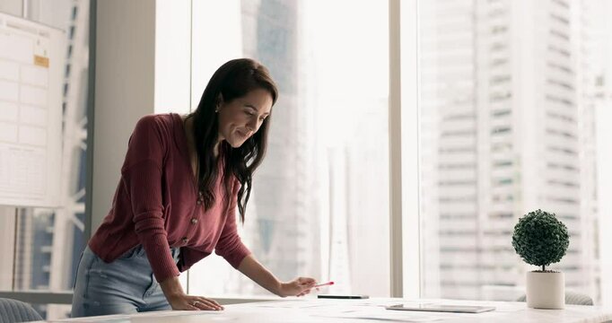 Serious businesswoman, accountant, analyst make paperwork, review sales results, marketing campaign efficiency, working in boardroom, learn infographic, analyze revenue, make conclusions based on data