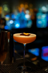 Colorful isolated cocktail glass with blurred background. Drink in a bar party vibe fresh drink with banana and ice on top closeup photo. Cocktail with bokeh at the background. 