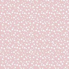Seamless pattern of irregular white dots on a pastel pink background