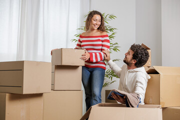 Excited young couple in their new house. They are unpacking their belongings for their new life. Real estate, home sales