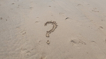 Question word on yellow sand background on the beach.