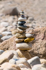 A cairn, rock pile, or stone structure on the shore -concepts of peace, calm, grounding, and meditation. Rock piles are prohibited in protected lands as it is counter to the leave-no-trace principle.