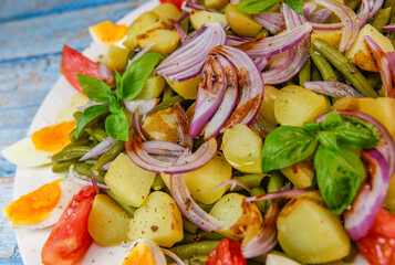 Fresh salad, green beans, small potatoes, egg, tomato, basil, red onions and balsamic vinaigrette. High quality photo