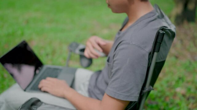 Programmer busy work hard developing new software writing program code on a laptop. Work stress, stiff neck relief pain ache, suffer burnout brownout office syndrome,  anxiety, working in a park.