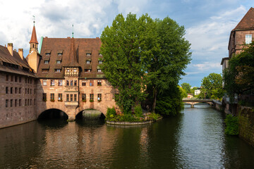 Obraz premium The building of Heilig Geist Spital located on the Pegnitz river in Nuremberg.