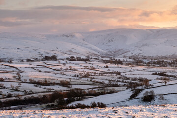 Winter landscape with snow covered mountains at sunset