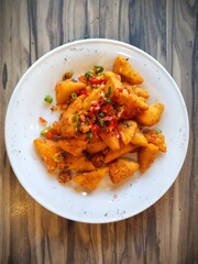 a plate of crispy Tahu Cabe Garam (chili salt tofu) snacks. Spicy fried tofu sprinkled with dried red and green chilies