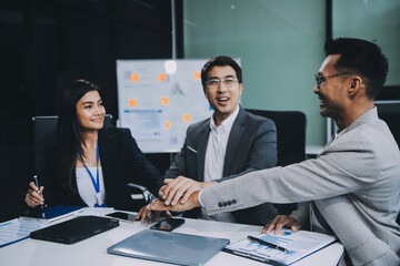 Group of colleagues engaging in a discussion during a business meeting in a conference room. Happy business people, men and women, collaborating and working towards their shared goals.