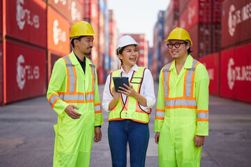 workers working on tablet for checking product in containers warehouse storage