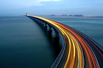 A long exposure shot of a bridge with cars driving across it at night. The bridge is lit up with streetlights and the car headlights are creating streaks of light