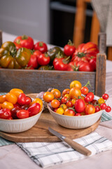 Auswahl verschiedener Tomaten in der Küche, viele Sorten Tomaten, frisches Gemüse zubereiten