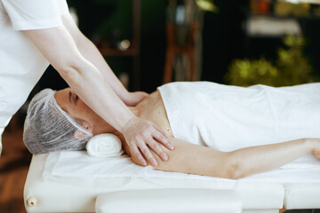 massage therapist massaging clients shoulder on massage table