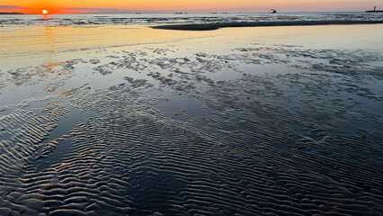Sunset over the sea. Sea beach at the setting sun.