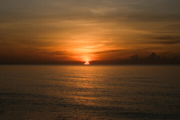 The sun rises at the sea in the morning.