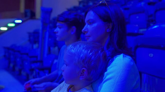Spectators in a circus. Happy family with small child watching a circus performance. Little boy applauds the performers. Simferopol, Crimea, Russia 2024