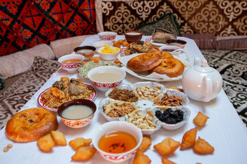 Meal with traditional Kyrgyz dishes served in the yurt. Local food in Kyrgyzstan.