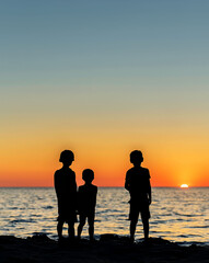 Fototapeta premium some children watching a sunset at the sea