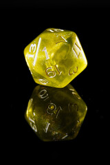 a translucent yellow twenty-sided dice with white numbers, showing the number one, on a black background with a reflection