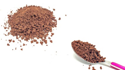 Top view of a spoonful and a heap of rich, aromatic instant coffee granules, ready to be brewed into a quick and stimulating cup of coffee, isolated on white background.