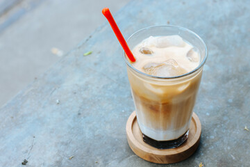 This drink is called palm sugar milk coffee, served with ice cubes in a glass. Photo taken from the top corner
