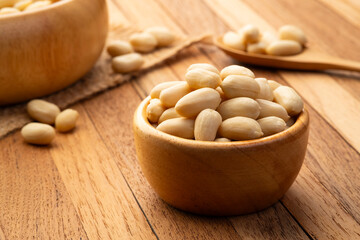 Raw Uncooked peeled peanuts(Arachis hypogaea) in wooden bowl.rich in protein,fat,and fiber