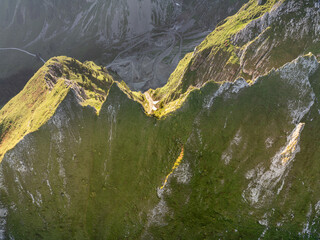 Aerial view of mountain landscape in Switzerland. Peaks in Gantrisch nature park in Swiss alps. Beautiful panorama in morning sunlight with blue sky.