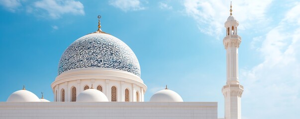 White mosque with blue dome against a bright blue sky.