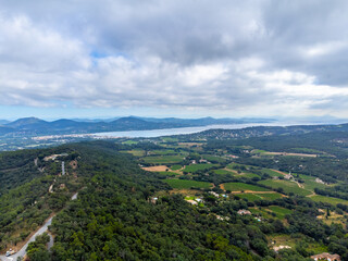 Fototapeta premium Aerial view on green hills, houses, gulf of saint-tropez, Gassin village, vineyards, Provence, Var, France
