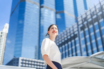 Portrait of successful business asian woman standing looking forward at outdoors in city