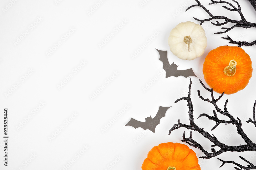 Poster halloween side border of spooky bats, black branches and pumpkins. overhead view on a white backgrou