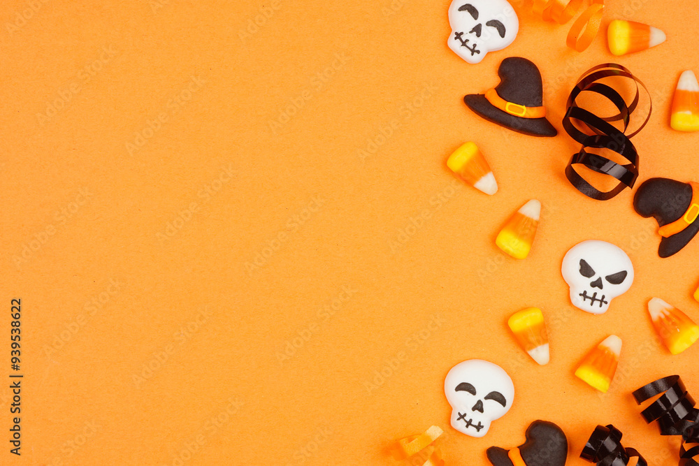 Poster halloween side border of black, white and orange color candy and ribbon. top down view on an orange 