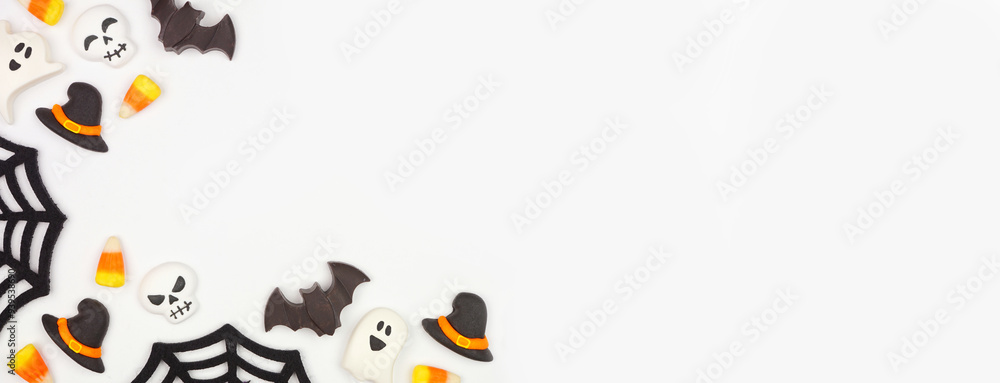Poster halloween corner border of black, white and orange color candy and spider webs. above view on a whit