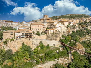 Fototapeta premium Aerial view of Cuenca historic town center with in La Mancha Spain, colorful medieval houses with hanging balcony blue cloudy sky