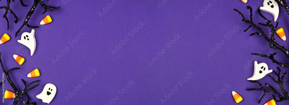 Poster halloween double border of spooky black branches and candy. above view over a purple banner backgrou