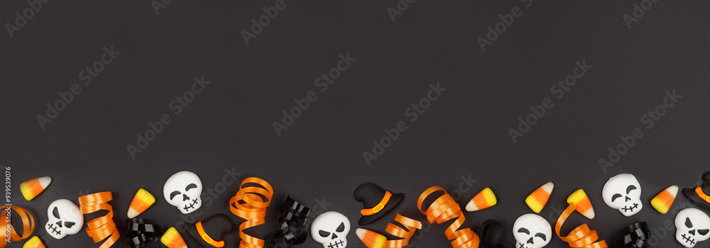 Poster halloween bottom border of black, white and orange color candy and ribbon. top down view on a black 