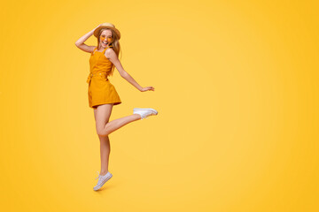 Carefree Youth. Full-Length Portrait Of Positive Teen Girl Jumping Over Yellow Studio Background, Free Space