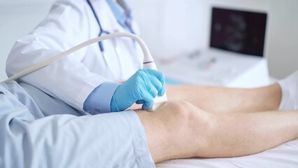 Fototapeta premium Doctor woman wearing blue medical gloves performing knee ultrasound exam on male patient with shorts . Medicine, orthopedic service concept