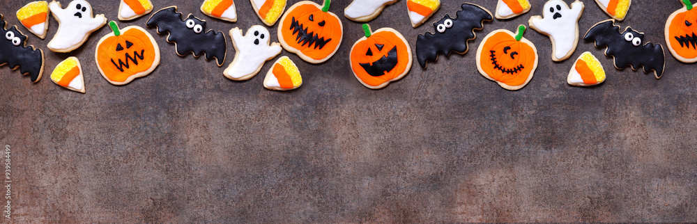 Poster halloween cookie top border. overhead view on a dark stone banner background with copy space. ghosts