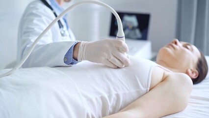 Fototapeta premium Doctor man using ultrasound equipment on the breast of a female patient. Female breast cancer prevention. mammary gland health. Medicine concept