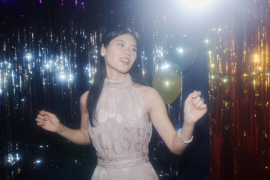 Person enjoying dance under sparkling lights at festive event. Captured at moment of pure happiness and carefree enjoyment 